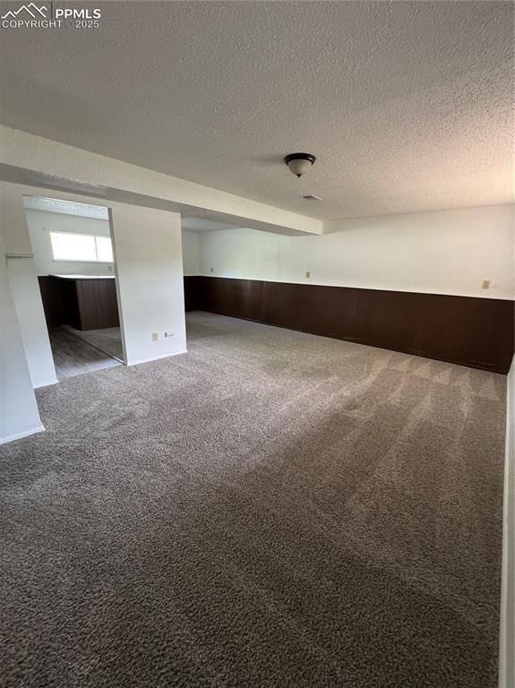 1402 Yosemite Dr, Colorado Springs, CO 80910 - unfurnished room with carpet floors, a textured ceiling, and a wainscoted wall