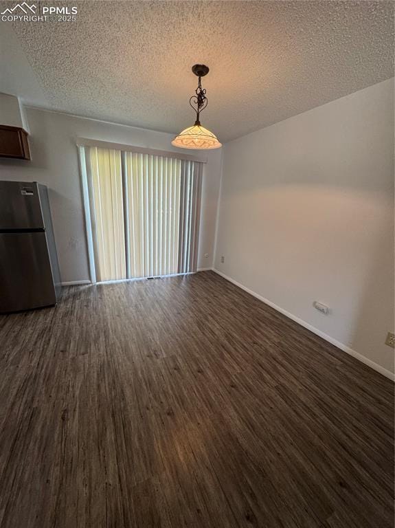 1402 Yosemite Dr, Colorado Springs, CO 80910 - unfurnished dining area with dark wood-style floors, a textured ceiling, and baseboards