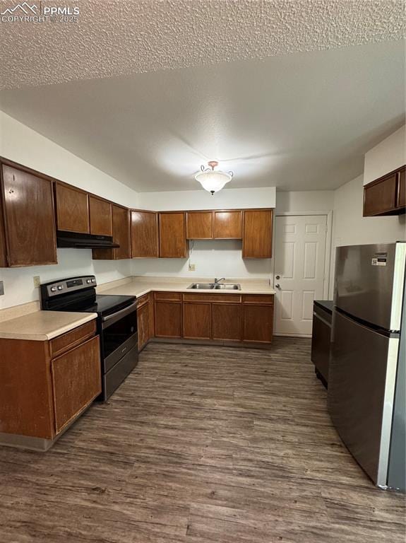 1402 Yosemite Dr, Colorado Springs, CO 80910 - kitchen featuring stainless steel appliances, under cabinet range hood, a sink, dark wood-style floors, and a textured ceiling