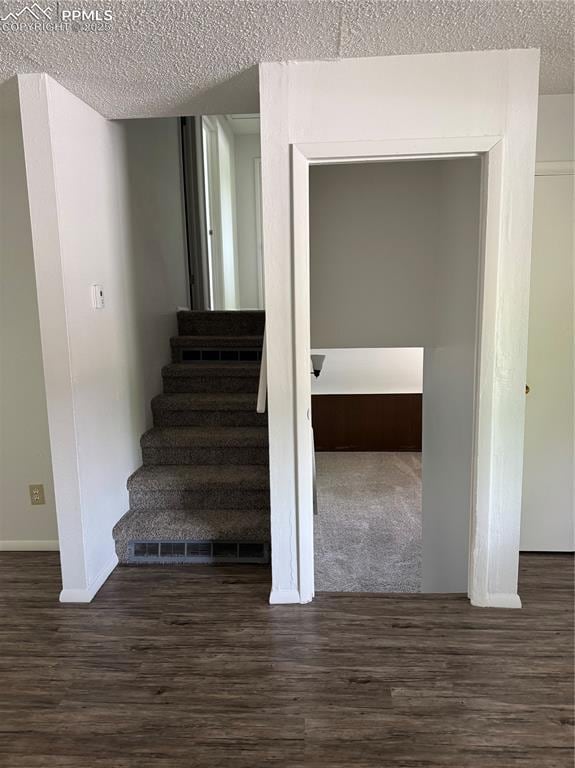 1402 Yosemite Dr, Colorado Springs, CO 80910 - staircase featuring a textured ceiling, wood finished floors, and baseboards