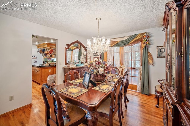 435 W Woodmen Rd, Colorado Springs, CO 80919 - dining room with a chandelier, a textured ceiling, light wood finished floors, and baseboards