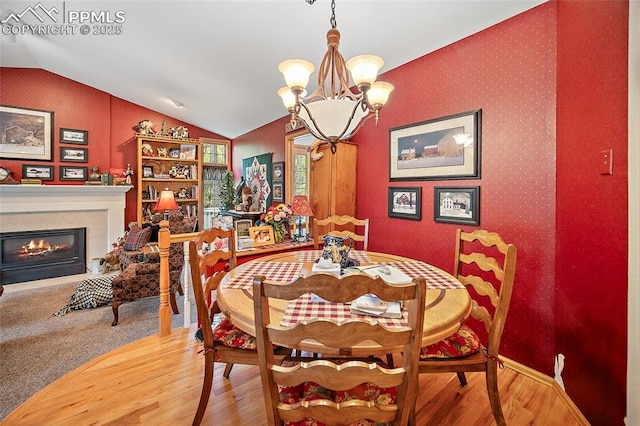 435 W Woodmen Rd, Colorado Springs, CO 80919 - dining room featuring a chandelier, wood finished floors, lofted ceiling, wallpapered walls, and a glass covered fireplace