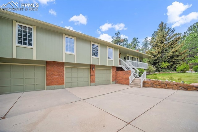435 W Woodmen Rd, Colorado Springs, CO 80919 - view of front of house with brick siding, an attached garage, driveway, and stairs