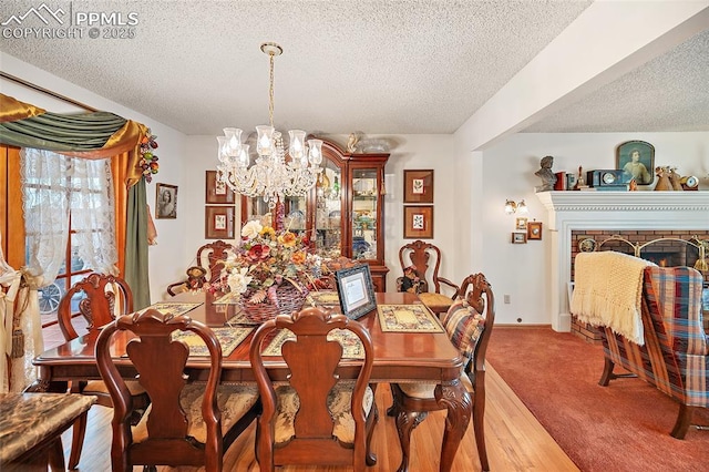 435 W Woodmen Rd, Colorado Springs, CO 80919 - dining space featuring a chandelier, a textured ceiling, and a fireplace