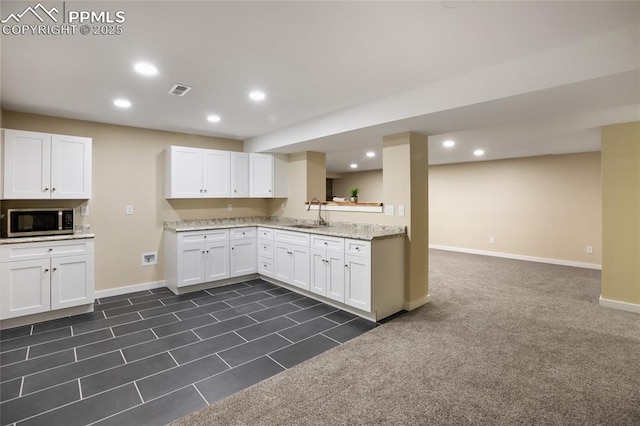 595 Wintery Cir, Colorado Springs, CO 80919 - kitchen with stainless steel microwave, baseboards, recessed lighting, white cabinets, and a sink