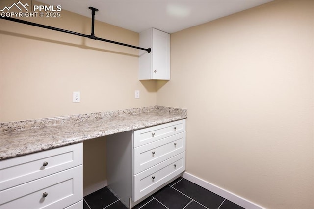 595 Wintery Cir, Colorado Springs, CO 80919 - kitchen with white cabinetry, dark tile patterned flooring, light countertops, and baseboards