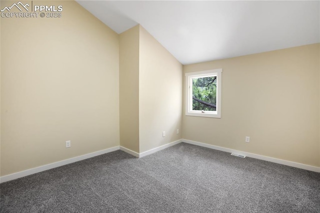 595 Wintery Cir, Colorado Springs, CO 80919 - empty room featuring lofted ceiling, dark carpet, and baseboards