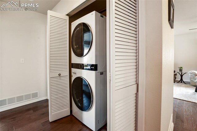 7833 Bengali Ln, Colorado Springs, CO 80923 - washroom with stacked washing machine and dryer, dark wood-style floors, and baseboards