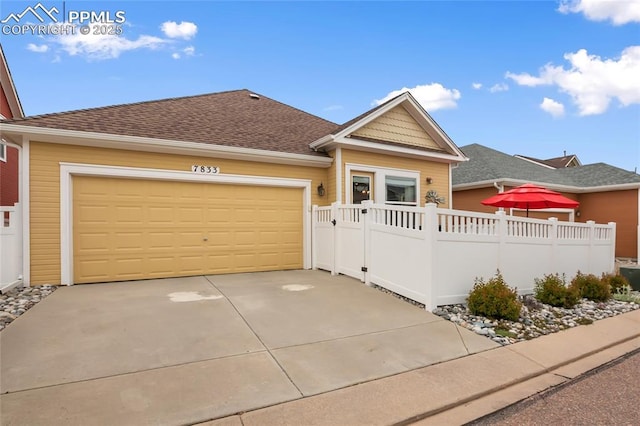 7833 Bengali Ln, Colorado Springs, CO 80923 - view of front of home with driveway, an attached garage, and a shingled roof
