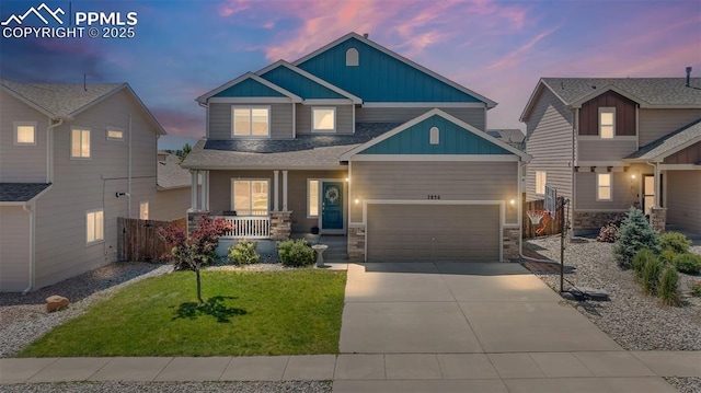 7856 Calabash Rd, Colorado Springs, CO 80908 - craftsman-style home with a porch, board and batten siding, concrete driveway, an attached garage, and stone siding