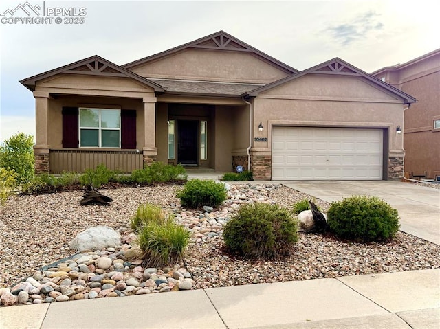 10402 Capital Peak Way, Peyton, CO 80831 - view of front of home featuring stucco siding, concrete driveway, stone siding, a garage, and a porch