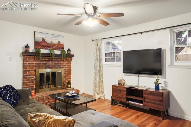 2417 Ranch Ln, Colorado Springs, CO 80918 - living area with wood finished floors, ceiling fan, healthy amount of natural light, and a brick fireplace