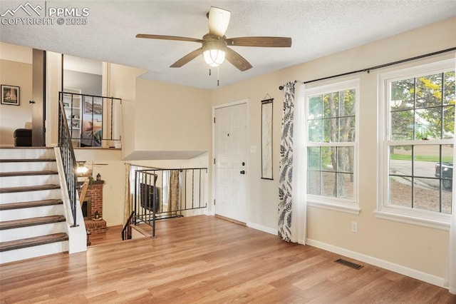 2417 Ranch Ln, Colorado Springs, CO 80918 - entryway with light wood-style floors, stairs, ceiling fan, baseboards, and a textured ceiling