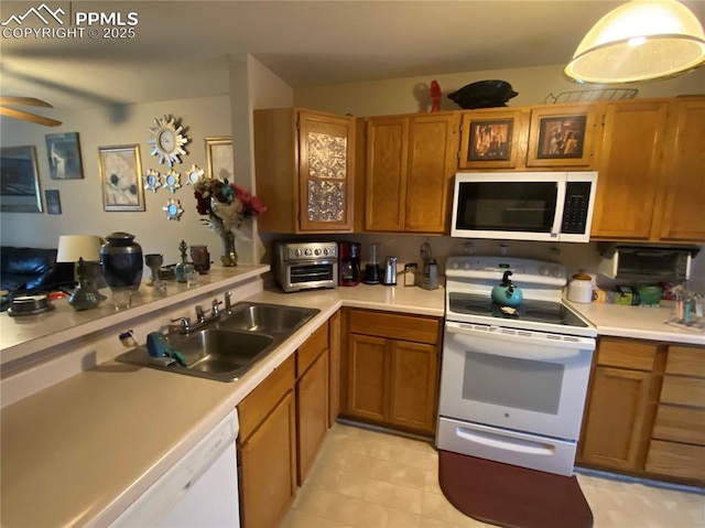 967 Brant Hollow Ct, Colorado Springs, CO 80916 - kitchen with white appliances, a sink, light countertops, and brown cabinetry