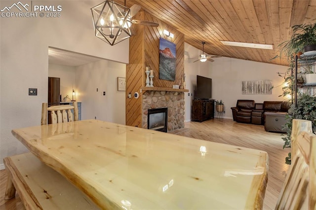 417 W Columbine Ave, Woodland Park, CO 80863 - dining space with ceiling fan, a stone fireplace, wood finished floors, baseboards, and high vaulted ceiling