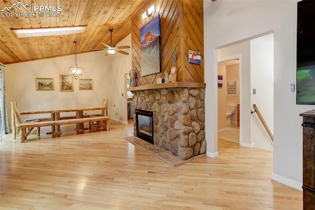 417 W Columbine Ave, Woodland Park, CO 80863 - living room with a ceiling fan, a fireplace, light wood-style flooring, wood ceiling, and baseboards
