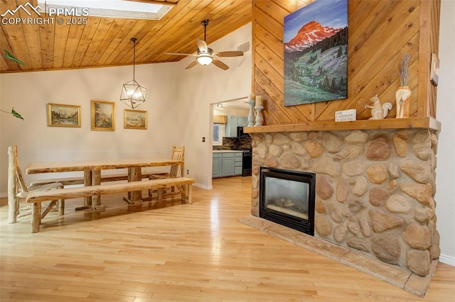 417 W Columbine Ave, Woodland Park, CO 80863 - dining room with vaulted ceiling, light wood-style flooring, a skylight, a ceiling fan, and a fireplace