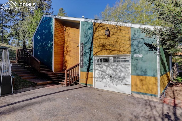 417 W Columbine Ave, Woodland Park, CO 80863 - view of front facade featuring asphalt driveway, a garage, and stairs