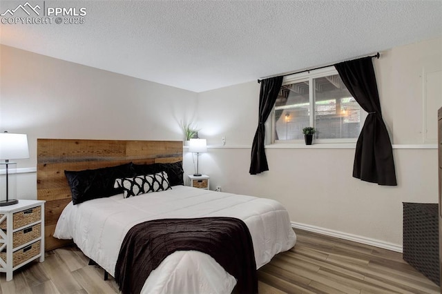 417 W Columbine Ave, Woodland Park, CO 80863 - bedroom with wood finished floors, a textured ceiling, and baseboards