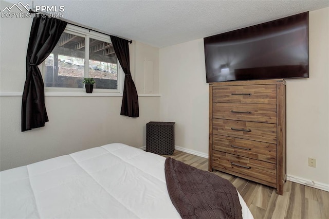 417 W Columbine Ave, Woodland Park, CO 80863 - bedroom featuring wood finished floors, baseboards, and a textured ceiling
