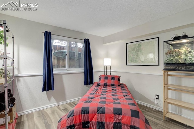 417 W Columbine Ave, Woodland Park, CO 80863 - bedroom with wood finished floors, a textured ceiling, and baseboards