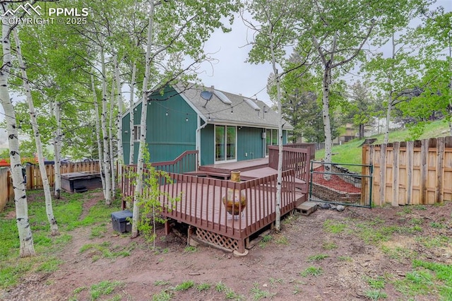 417 W Columbine Ave, Woodland Park, CO 80863 - back of property with a fenced backyard, a deck, a shingled roof, and a hot tub