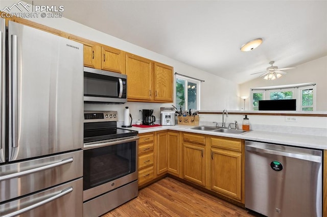 5630 Almont Ave, Colorado Springs, CO 80911 - kitchen with stainless steel appliances, a sink, light countertops, light wood-type flooring, and vaulted ceiling