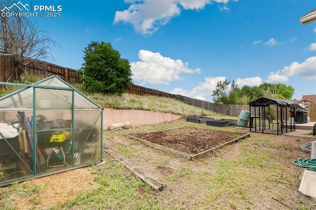 5630 Almont Ave, Colorado Springs, CO 80911 - fenced backyard featuring a vegetable garden, a greenhouse, and an outbuilding