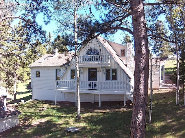 845 Markus Rd, Woodland Park, CO 80863 - back of house with a balcony, a chimney, board and batten siding, and a yard