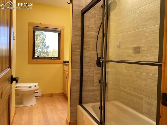 845 Markus Rd, Woodland Park, CO 80863 - full bathroom with baseboard heating, toilet, wood finished floors, shower / bath combination with glass door, and baseboards