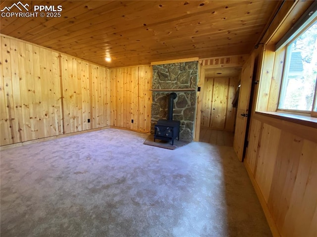845 Markus Rd, Woodland Park, CO 80863 - unfurnished living room with wooden ceiling, wooden walls, and a wood stove