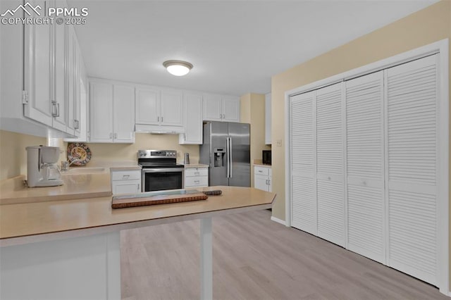 751 Crown Ridge Dr, Colorado Springs, CO 80904 - kitchen featuring stainless steel appliances, under cabinet range hood, light countertops, a peninsula, and white cabinetry