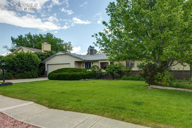 751 Crown Ridge Dr, Colorado Springs, CO 80904 - ranch-style house featuring a garage, a front lawn, driveway, and a chimney