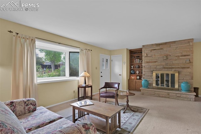 751 Crown Ridge Dr, Colorado Springs, CO 80904 - carpeted living area with built in shelves, a stone fireplace, and baseboards