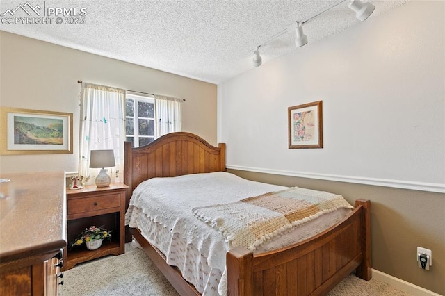 3870 Chinawood Ct, Colorado Springs, CO 80918 - bedroom with rail lighting, carpet flooring, and a textured ceiling