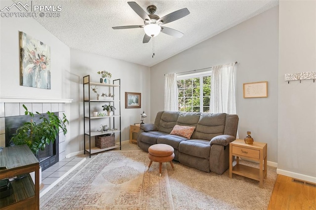 3870 Chinawood Ct, Colorado Springs, CO 80918 - living area with ceiling fan, a textured ceiling, vaulted ceiling, a tiled fireplace, and wood finished floors
