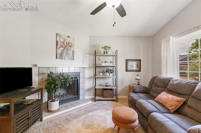 3870 Chinawood Ct, Colorado Springs, CO 80918 - living area with a textured ceiling, ceiling fan, a fireplace, baseboards, and tile patterned floors