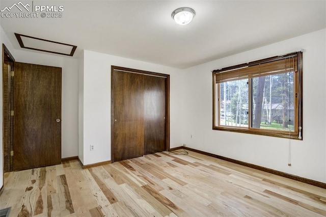 1015 Lafayette Ave, Woodland Park, CO 80863 - unfurnished bedroom featuring attic access, a closet, light wood-style floors, and baseboards