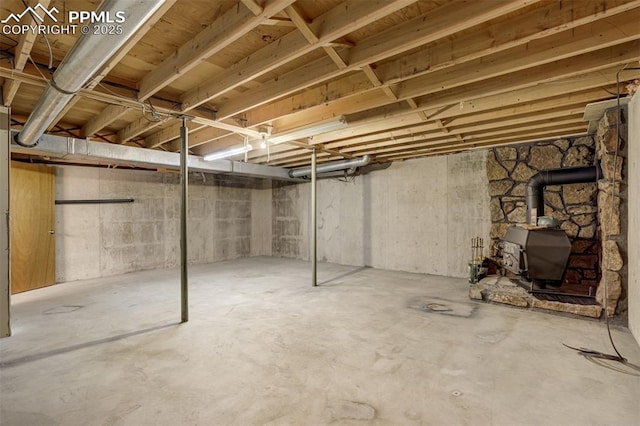 1015 Lafayette Ave, Woodland Park, CO 80863 - unfinished below grade area featuring a wood stove and a heating unit