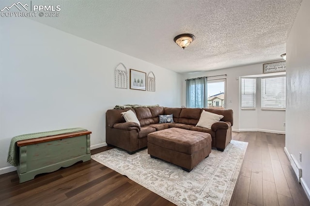 1155 Hallamwood Dr, Colorado Springs, CO 80911 - living room featuring dark wood-style floors, a textured ceiling, baseboards, and a baseboard heating unit