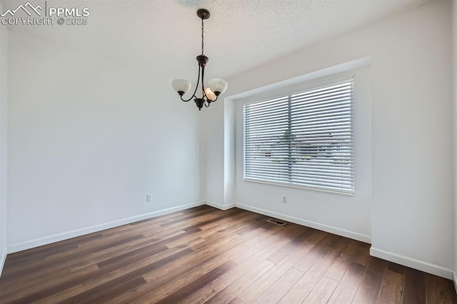 1155 Hallamwood Dr, Colorado Springs, CO 80911 - empty room with a chandelier, dark wood-type flooring, baseboards, and a textured ceiling