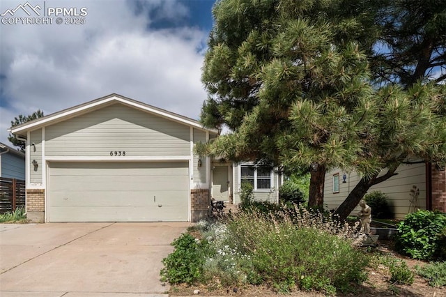 6938 Big Timber Dr, Colorado Springs, CO 80923 - view of front of property with concrete driveway, brick siding, and an attached garage