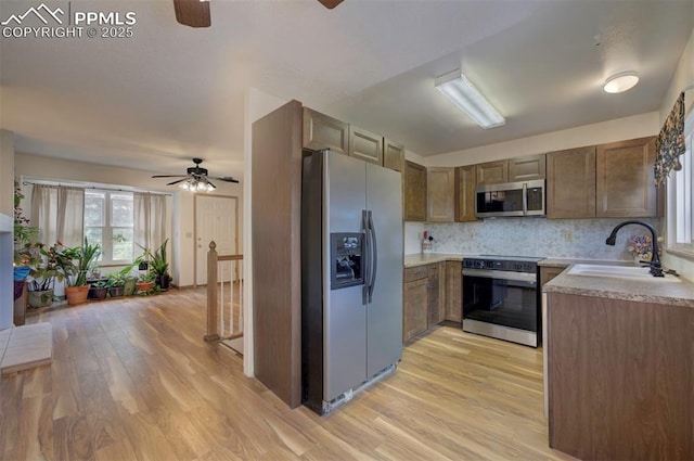 6938 Big Timber Dr, Colorado Springs, CO 80923 - kitchen with stainless steel appliances, ceiling fan, a sink, light wood-style floors, and light countertops