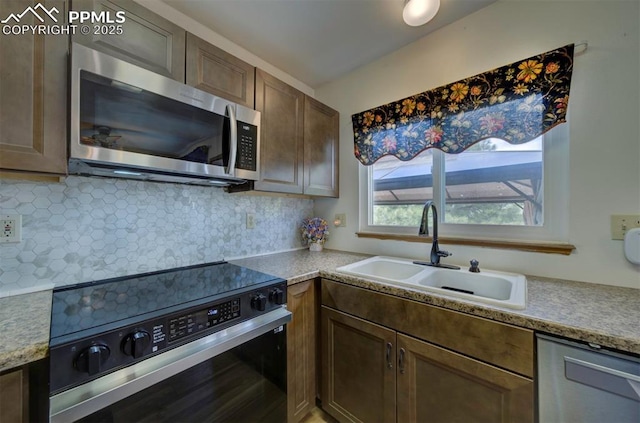 6938 Big Timber Dr, Colorado Springs, CO 80923 - kitchen with stainless steel appliances, a sink, backsplash, and light countertops