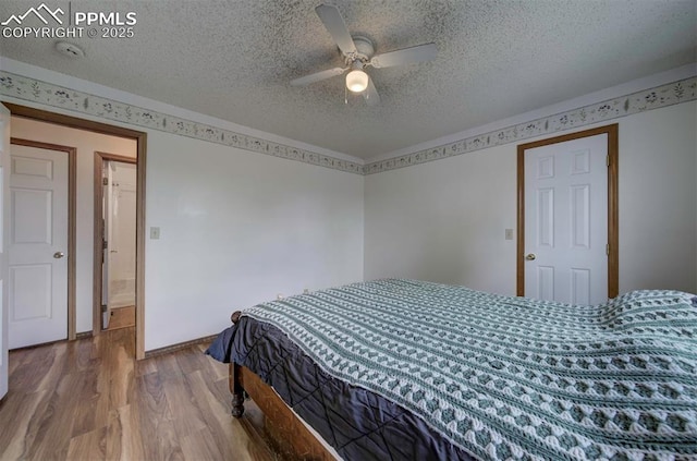 6938 Big Timber Dr, Colorado Springs, CO 80923 - bedroom featuring wood finished floors, a textured ceiling, and a ceiling fan