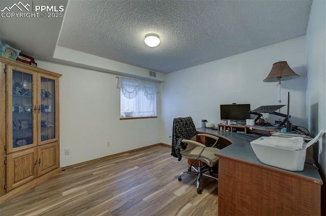 6938 Big Timber Dr, Colorado Springs, CO 80923 - office area with wood finished floors, a textured ceiling, and baseboards