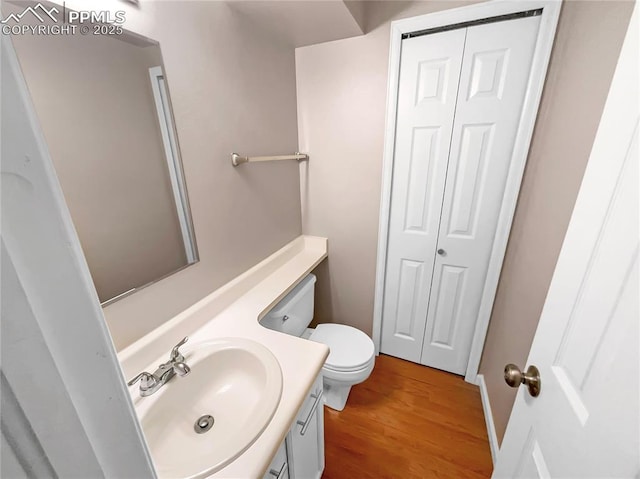412 Cobblestone Dr, Colorado Springs, CO 80906 - half bath with toilet, vanity, a closet, and wood finished floors