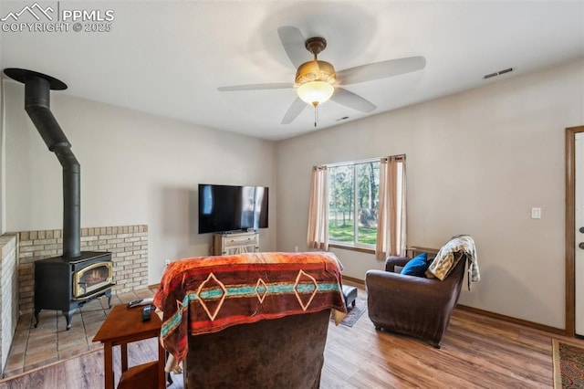14810 Tanner Trl, Elbert, CO 80106 - living room featuring a wood stove, ceiling fan, wood finished floors, and baseboards