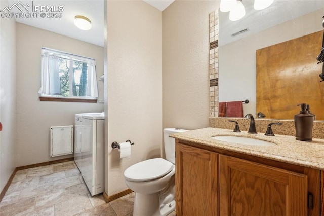 14810 Tanner Trl, Elbert, CO 80106 - bathroom featuring washer / dryer, vanity, toilet, baseboards, and stone finish floors