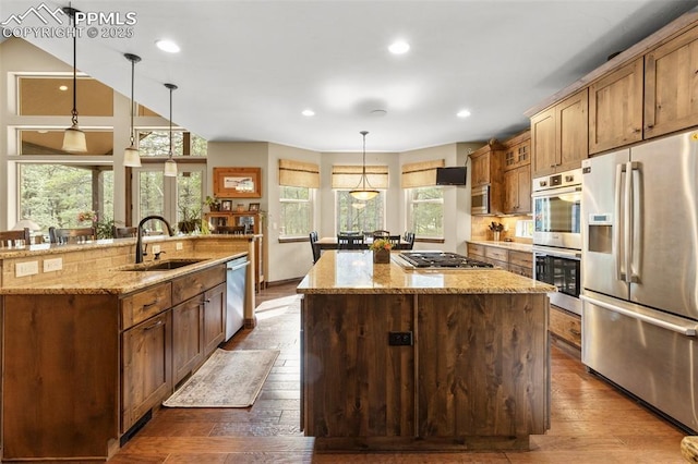 11720 Smokey Hill Grv, Colorado Springs, CO 80908 - kitchen featuring appliances with stainless steel finishes, a kitchen island with sink, dark wood-style floors, light stone counters, and recessed lighting